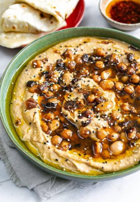 Hummus topped with beans in a green bowl