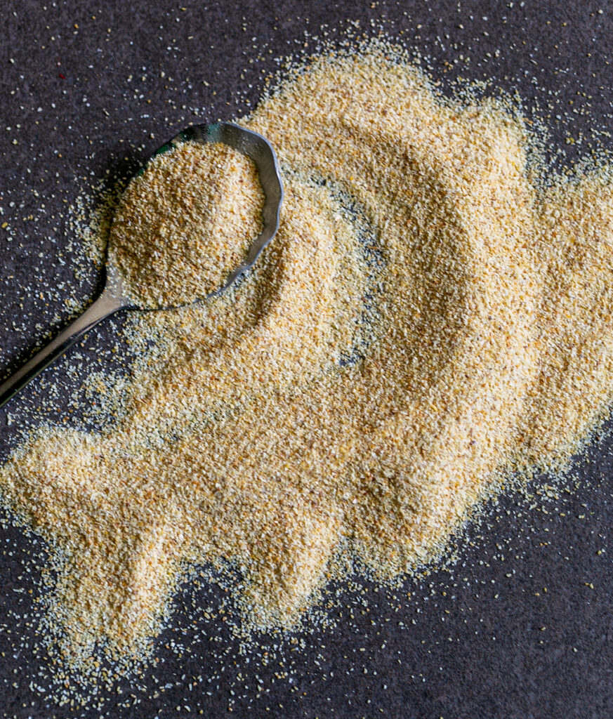 Garlic Powder with a spoon spread over a grey stone table