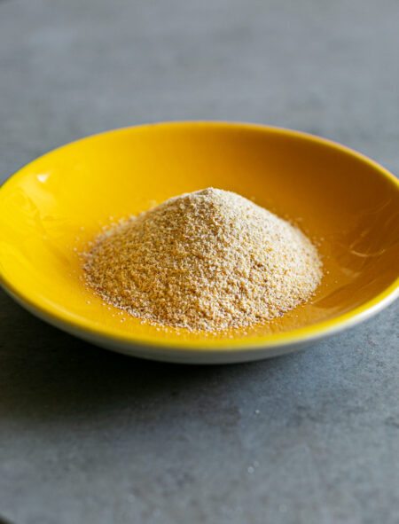 Garlic Powder in a small yellow bowl on a grey stone table