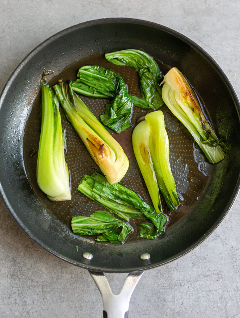 small black nonstick frying pan filled with bok choy