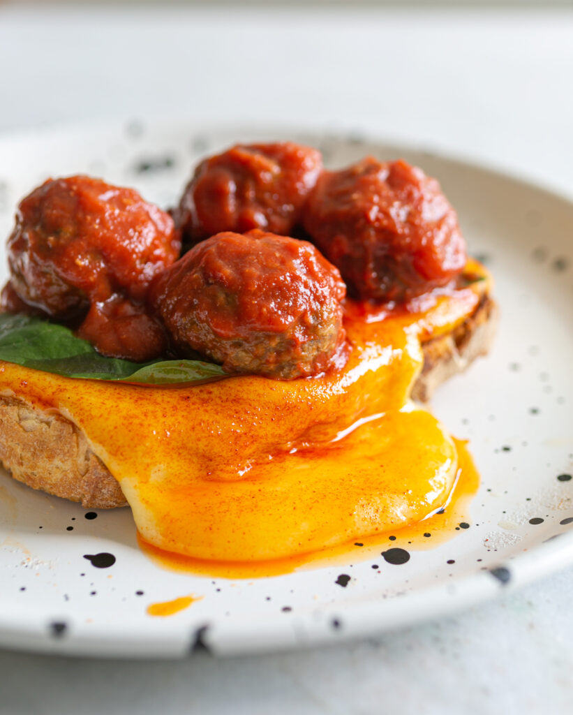 Fondue Meatball Sando. Toast topped with melted fondue cheese sauce, basil and meatballs in tomato sauce