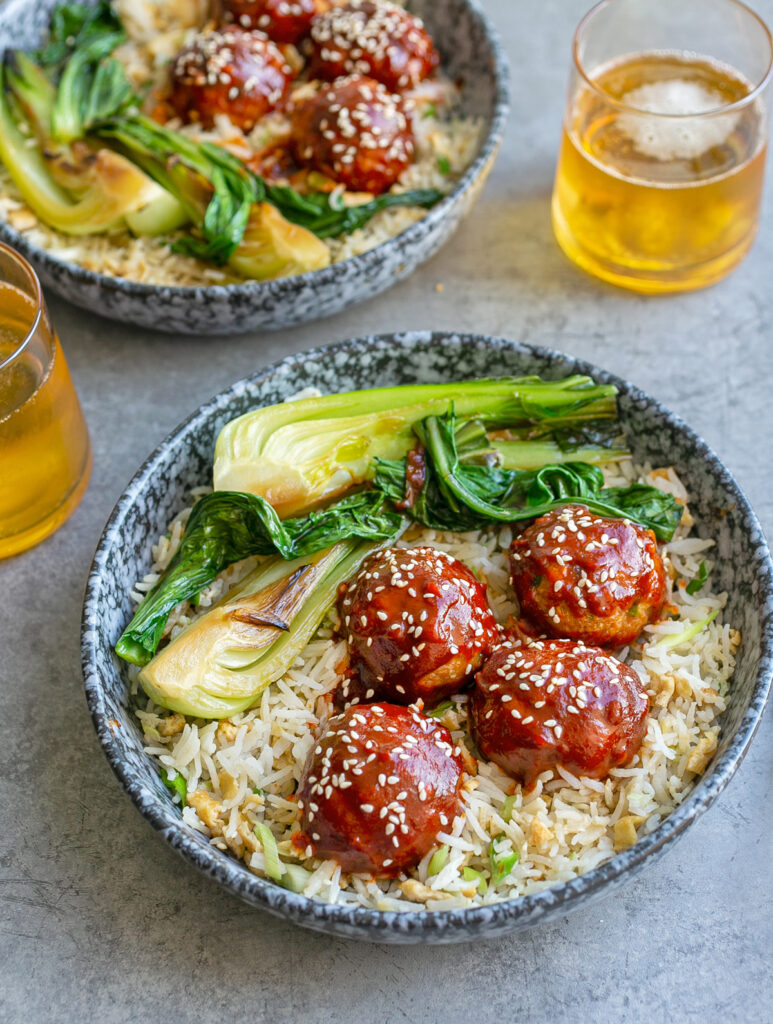 blue ceramic bowls filled with Gochujang Meatballs and Egg Rice and beers