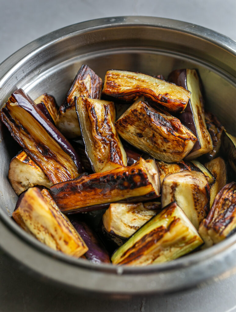 Metal bowl filled with large pieces of fried aubergine