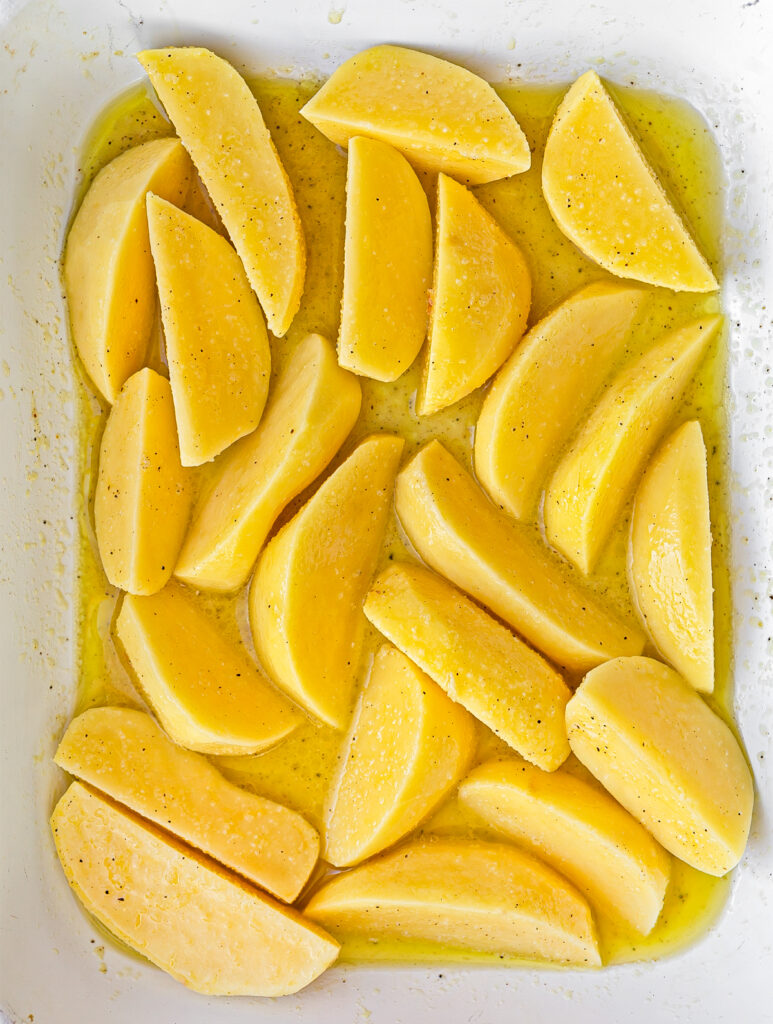 Garlic Butter Lemon Potato wedges in a roasting tray