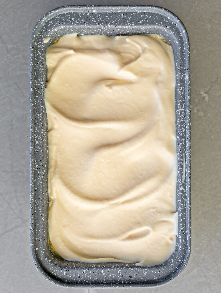 grey freezer container filled with Passion Fruit No Churn Ice Cream