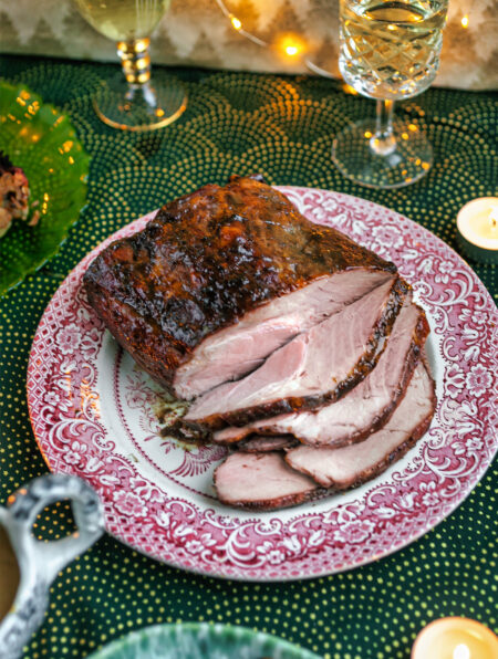 Christmas table setting with a carved Marmalade Rum Glazed Pork Shoulder Roast