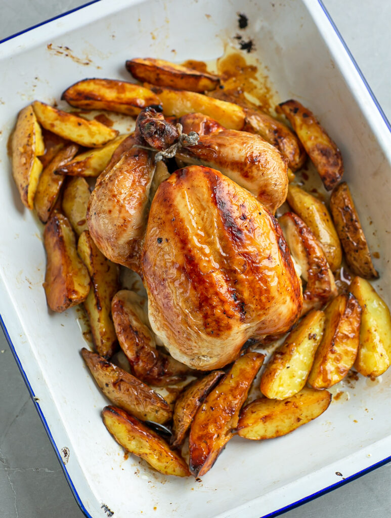 Oven roasting tray filled with roasted chicken and potaotes
