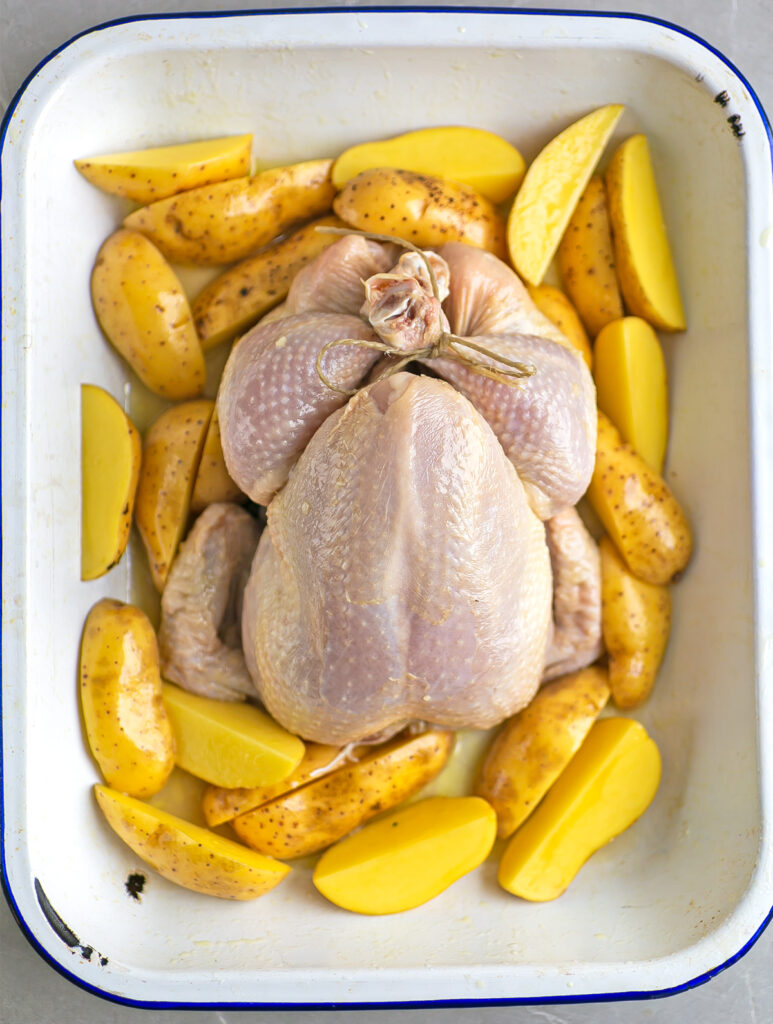 Oven roasting tray filled with roasted chicken and potatoes