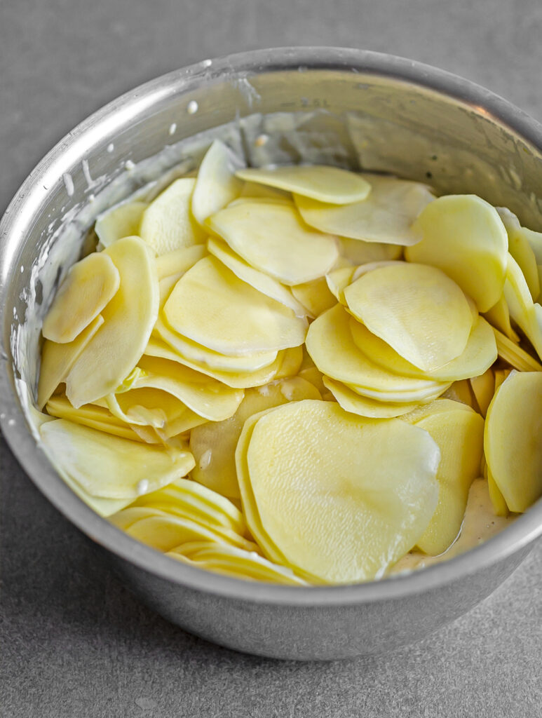 Pot of thinly sliced potatoes